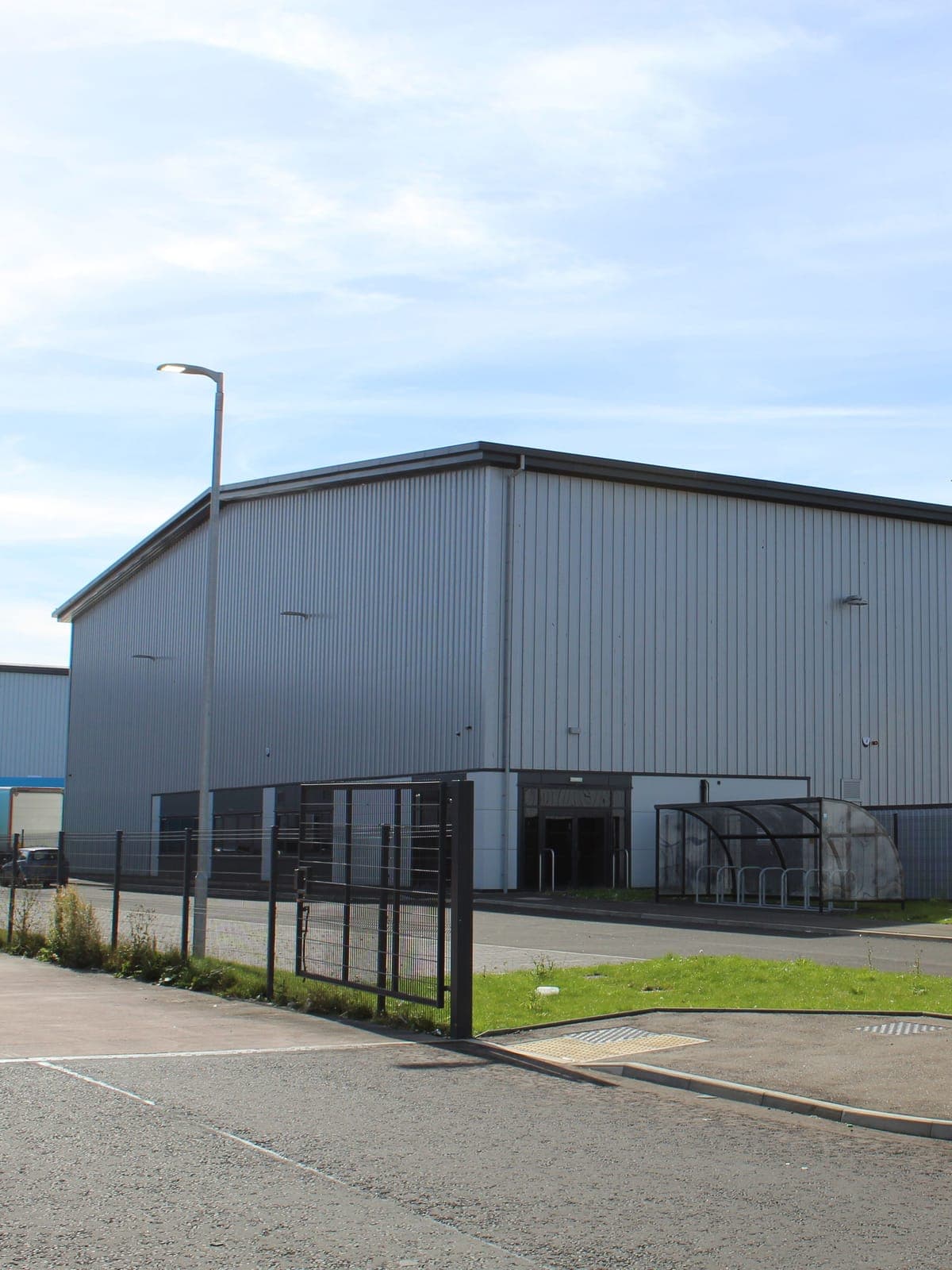 The end of the units in silver profiled cladding, with the entrance and bike shelter