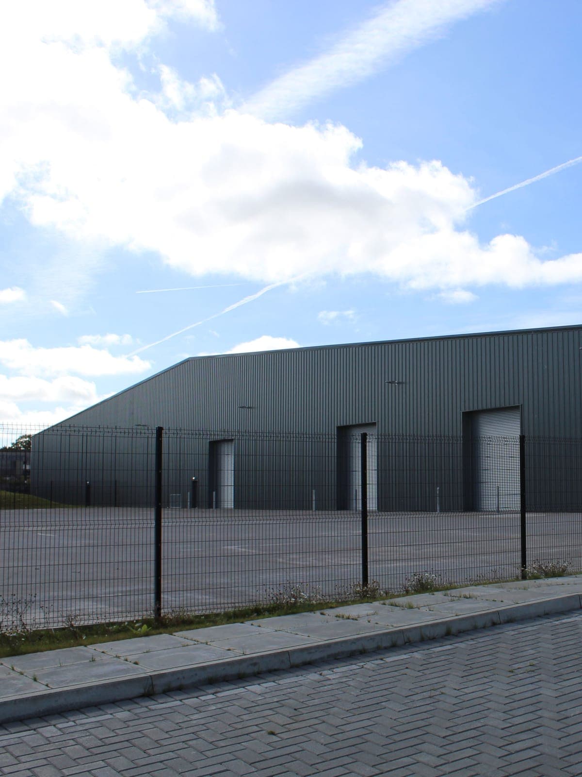 The warehouse from the yard: dark grey wall and roof panels
