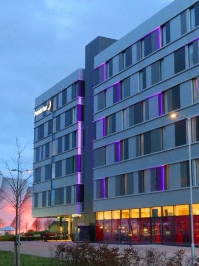 The hotel at dusk, with purple lighting between the window bands