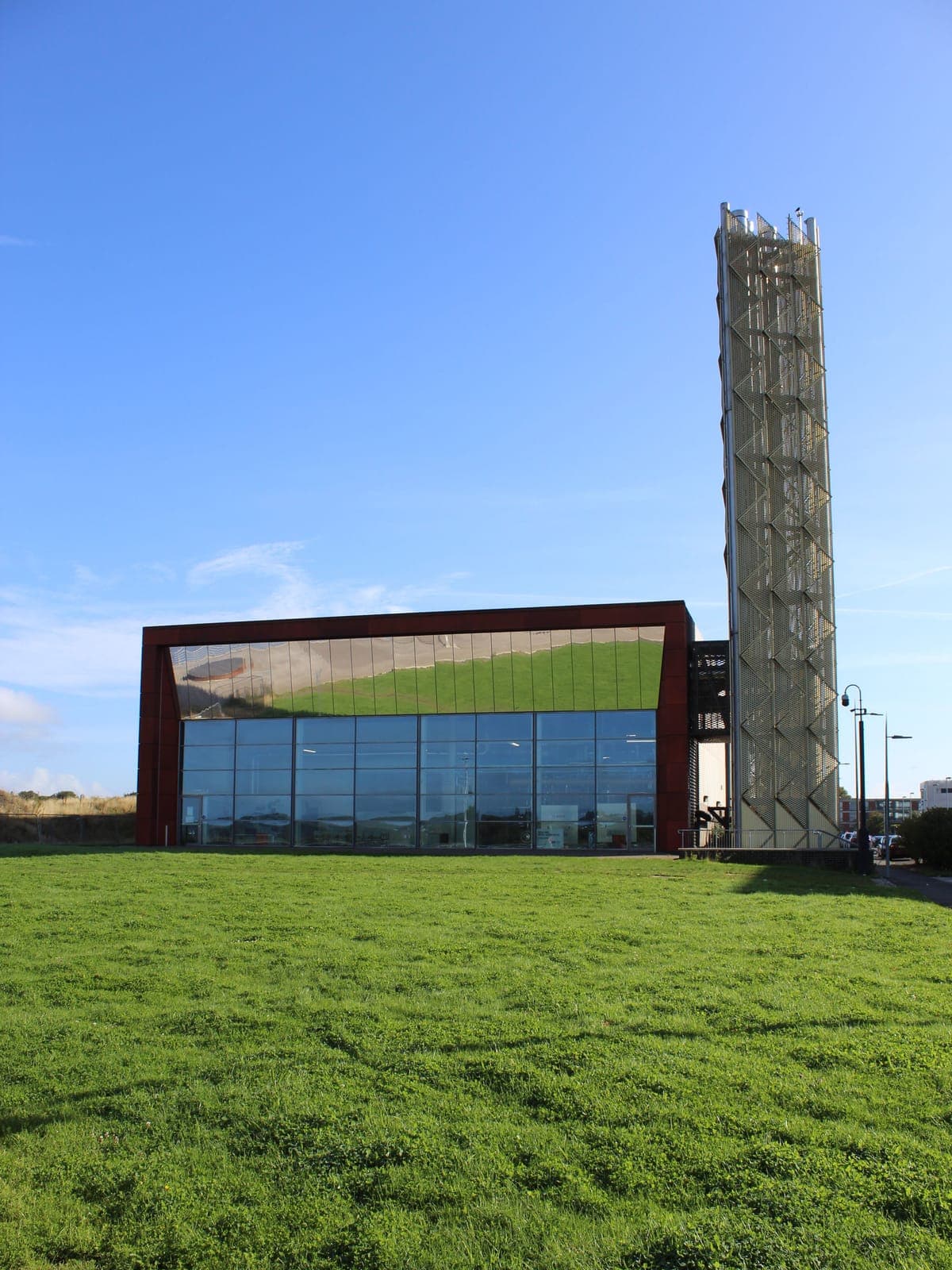 The glazed front in its corten-effect frame, with the flue tower behind